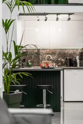 a kitchen with a green and white counter and stools at Studio Noir in Athens
