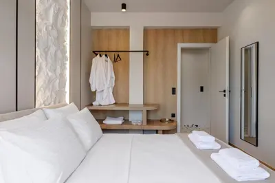 a bedroom with a large white bed with two towels at Thissio Acropolis Retreat in Athens