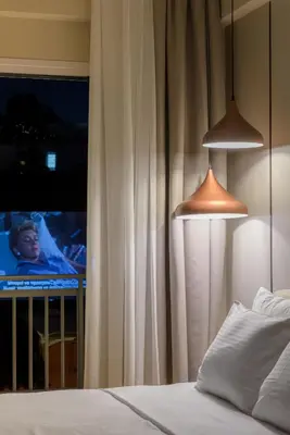 a bedroom with a bed and two lamps and a tv at Thissio Acropolis Retreat in Athens