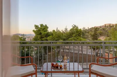a table with a bowl of fruit on a balcony at Thissio Acropolis Retreat in Athens