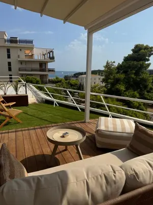 a living room with a couch and a table on a balcony at Athens Riviera Suite in Athens