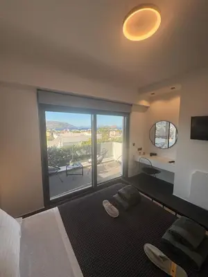 a bedroom with a bed and a large window at Escape Suites - Sea View in Porto Rafti