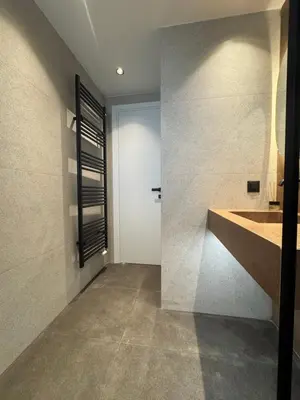 a bathroom with a large sink and a wall at Escape Suites - Sea View in Porto Rafti