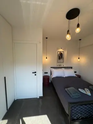 a bedroom with a bed and a sliding door at Escape Suites - Sea View in Porto Rafti
