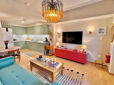 a living room with a blue couch and a kitchen at 70's Vintage Hideaway Appartment in Athens