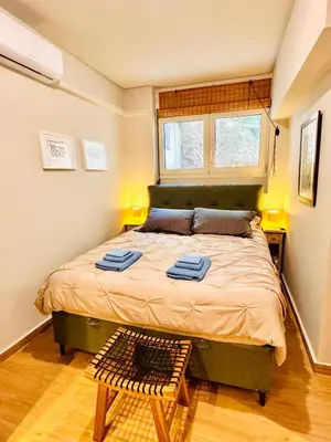 a bedroom with a large bed with two towels on it at 70's Vintage Hideaway Appartment in Athens