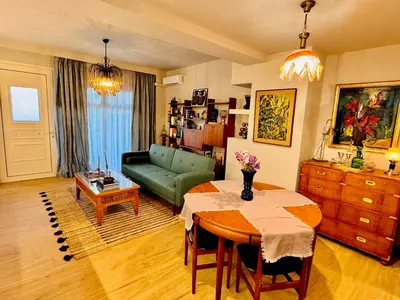 a living room with a table and a green couch at 70's Vintage Hideaway Appartment in Athens