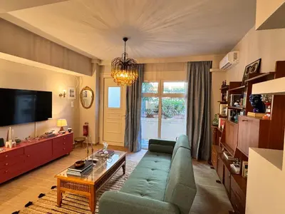 a living room with a blue couch and a tv at 70's Vintage Hideaway Appartment in Athens
