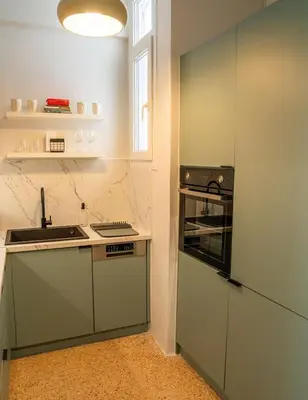 a kitchen with green cabinets and a sink at Philosykos Suite in Athens