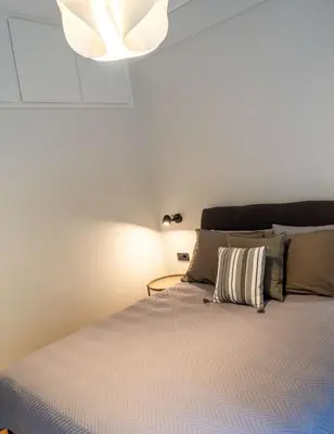a bedroom with a bed with a chandelier above it at Philosykos Suite in Athens