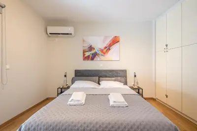 a bedroom with a bed with two towels on it at Cozy 2 bedroom flat near Gazi in Athens