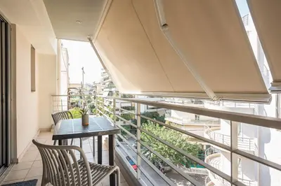 a balcony with a table and chairs and a window at Cozy 2 bedroom flat near Gazi in Athens