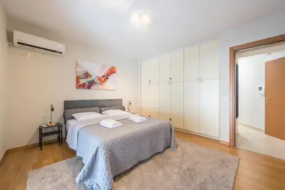 a white bedroom with a bed with two towels on it at Cozy 2 bedroom flat near Gazi in Athens