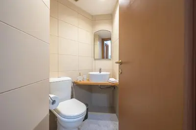 a bathroom with a white toilet and a sink at Cozy 2 bedroom flat near Gazi in Athens