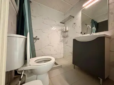 a white bathroom with a toilet and a sink at 2 bedroom near Dafni metro in Athens