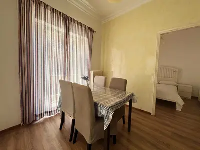 a dining room with a table and chairs and a window at 2 bedroom near Dafni metro in Athens