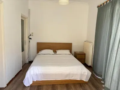 a bedroom with a large bed with white sheets at 2 bedroom near Dafni metro in Athens