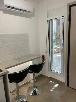a kitchen with a counter and two stools at Central Studio next to Metro in Piraeus