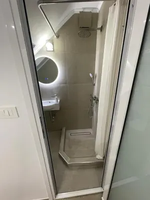 a small bathroom with a shower and a sink at Central Studio next to Metro in Piraeus