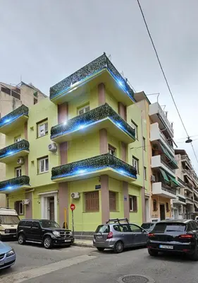 a yellow building with cars parked in front of it at Kresorts 13 in Athens