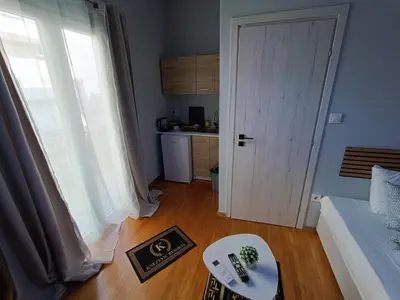 a room with a door and a table and a kitchen at Kresorts 13 in Athens
