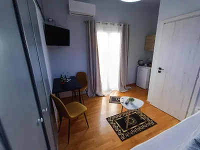 a living room with a table and chairs and a door at Kresorts 13 in Athens