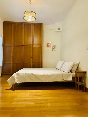 a bedroom with a bed and a wooden cabinet at Sem Athens House -entire 70m2 house- in Athens