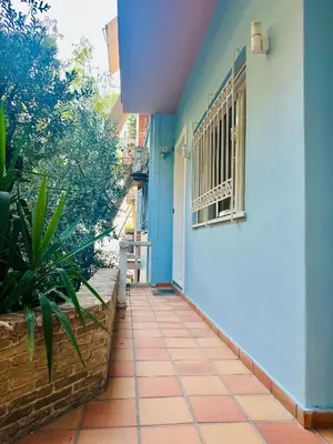 a blue and white building with a window and a sidewalk at Sem Athens House -entire 70m2 house- in Athens