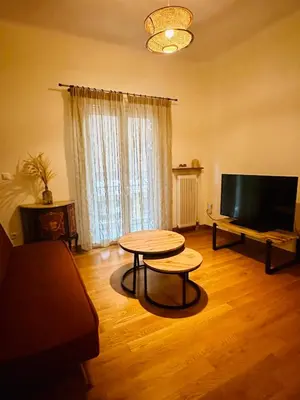 a living room with a table and a television at Sem Athens House -entire 70m2 house- in Athens