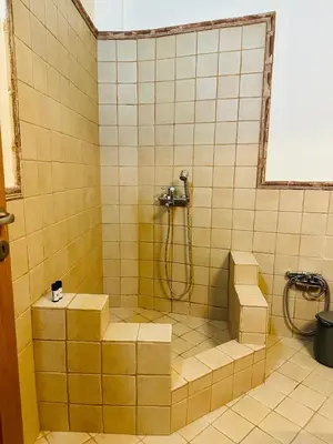 a yellow tiled bathroom with a shower and stairs at Sem Athens House -entire 70m2 house- in Athens