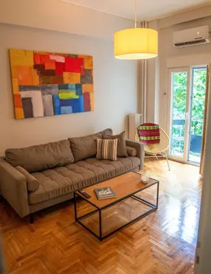 a living room with a couch and a table at The Fig Tree Flat in Athens