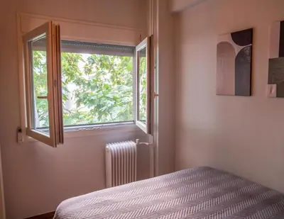 a bedroom with a bed and a window at The Fig Tree Flat in Athens