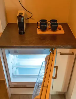 a refrigerator with three cups on a cutting board at The Fig Tree Flat in Athens