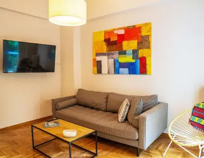 a living room with a couch and a painting at The Fig Tree Flat in Athens