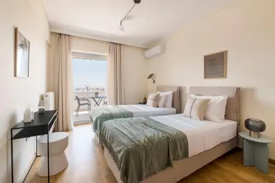 a hotel room with two beds and a balcony at Lightstone 3BR Living in Glyfada by UPSTREET in Athens