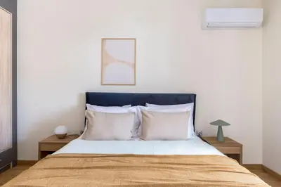 a bed with a blue headboard in a bedroom at Lightstone 3BR Living in Glyfada by UPSTREET in Athens