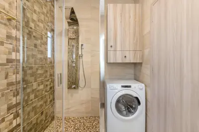 a bathroom with a washing machine and a shower at Lightstone 3BR Living in Glyfada by UPSTREET in Athens
