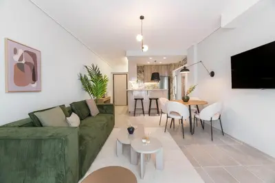 a living room with a green couch and a table at Lightstone 3BR Living in Glyfada by UPSTREET in Athens