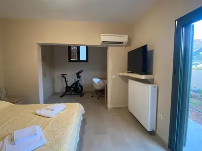a hotel room with a bed and a tv and a room with at EUPHORIA Pool Villa in Porto Rafti