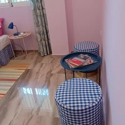 a room with two stools and a table with a book at Sunlit and cosy apartment in Athens