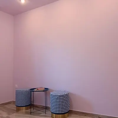 a room with two stools and a white wall at Sunlit and cosy apartment in Athens