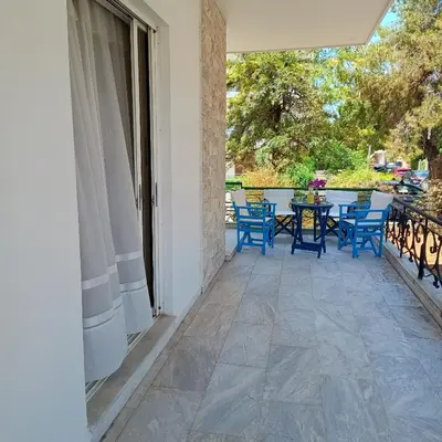 a patio with blue chairs and a table on it at Sunlit and cosy apartment in Athens
