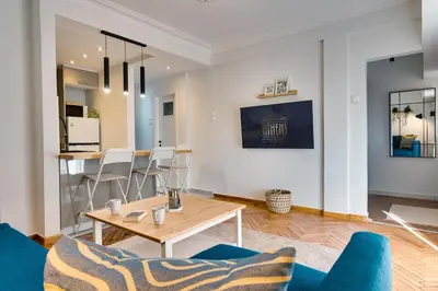 a living room with a table and blue chairs at Your peaceful corner in the city in Athens