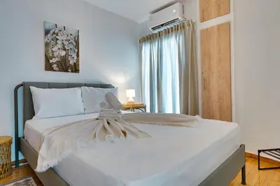 a bedroom with a large white bed with a window at Your peaceful corner in the city in Athens