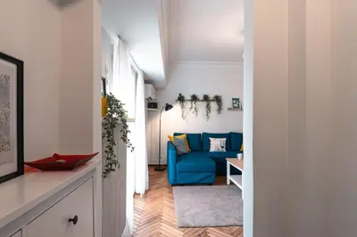 a living room with a blue couch and a table at Your peaceful corner in the city in Athens