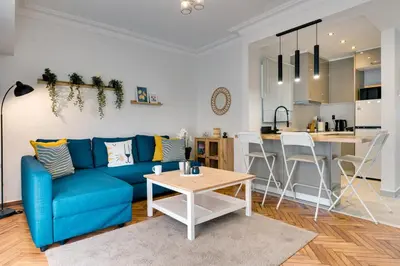 a living room with a blue couch and a table at Your peaceful corner in the city in Athens