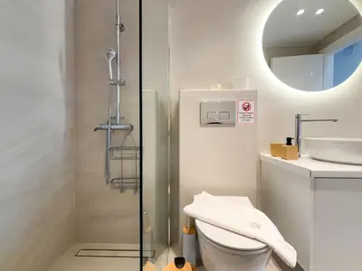 a bathroom with a shower and a toilet and a sink at Bright & Airy Flat in Voula Center in Athens