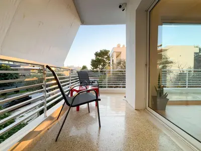 a chair sitting on the balcony of a house at Bright & Airy Flat in Voula Center in Athens