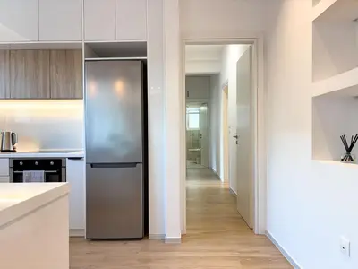 a kitchen with a stainless steel refrigerator and a hallway at Bright & Airy Flat in Voula Center in Athens