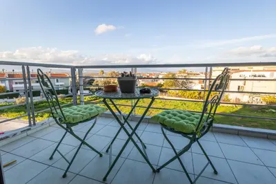 a table and chairs on a balcony with a view at Nancy view apartment in Markopoulo